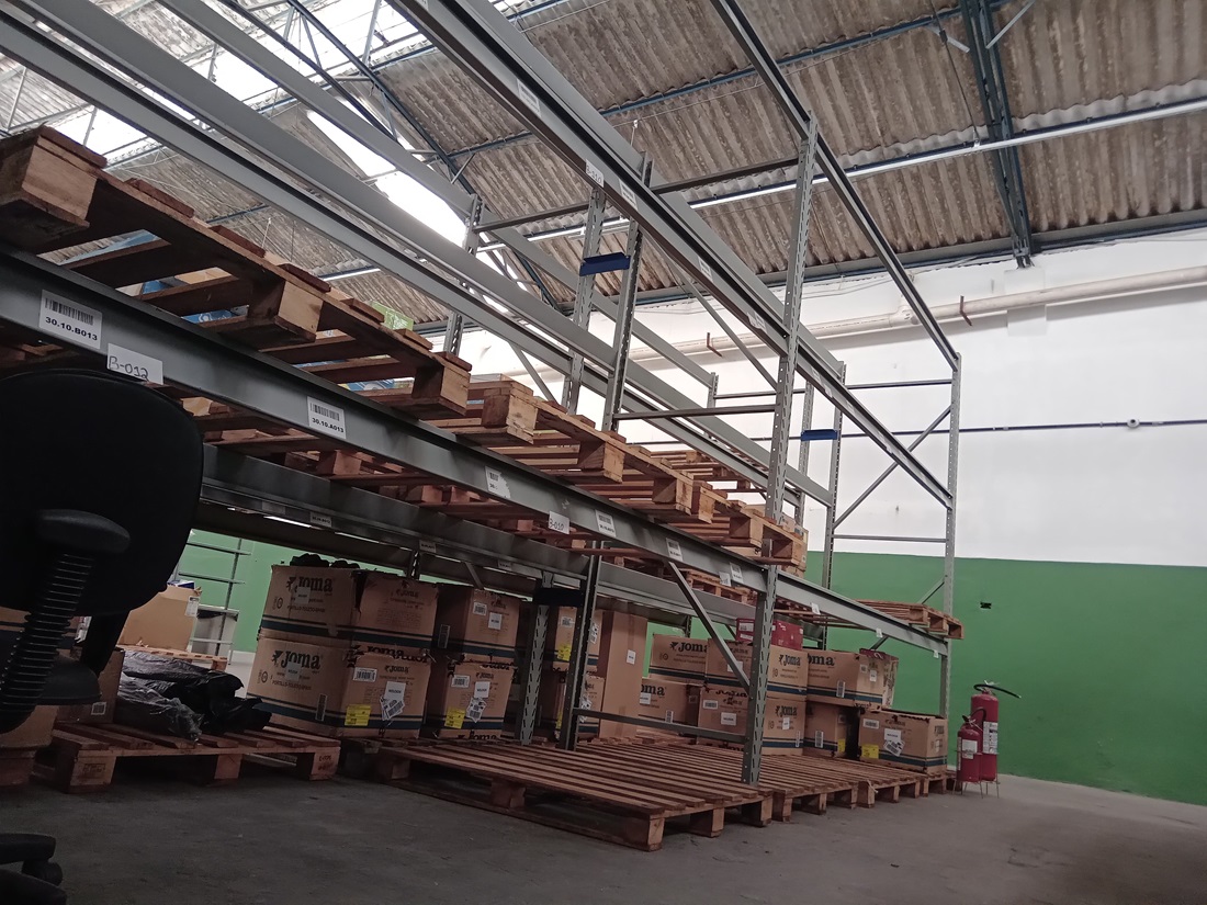 Interior da dark store em Cotia da Grin Store com uma estante repleta de pallets.